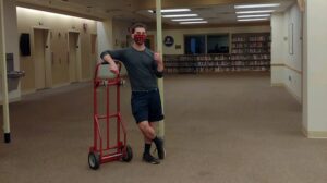 Library Assistant Zane stands in an empty fifth floor.