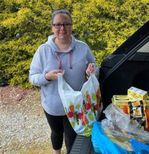 Dr. Alia Pustorino-Clevenger loads groceries into her car for delivery.