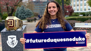 A photo of a student holding a sign that says #futureduquesneduke