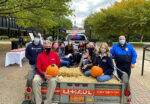 A photo of a group of people wearing masks in the back of a truck.